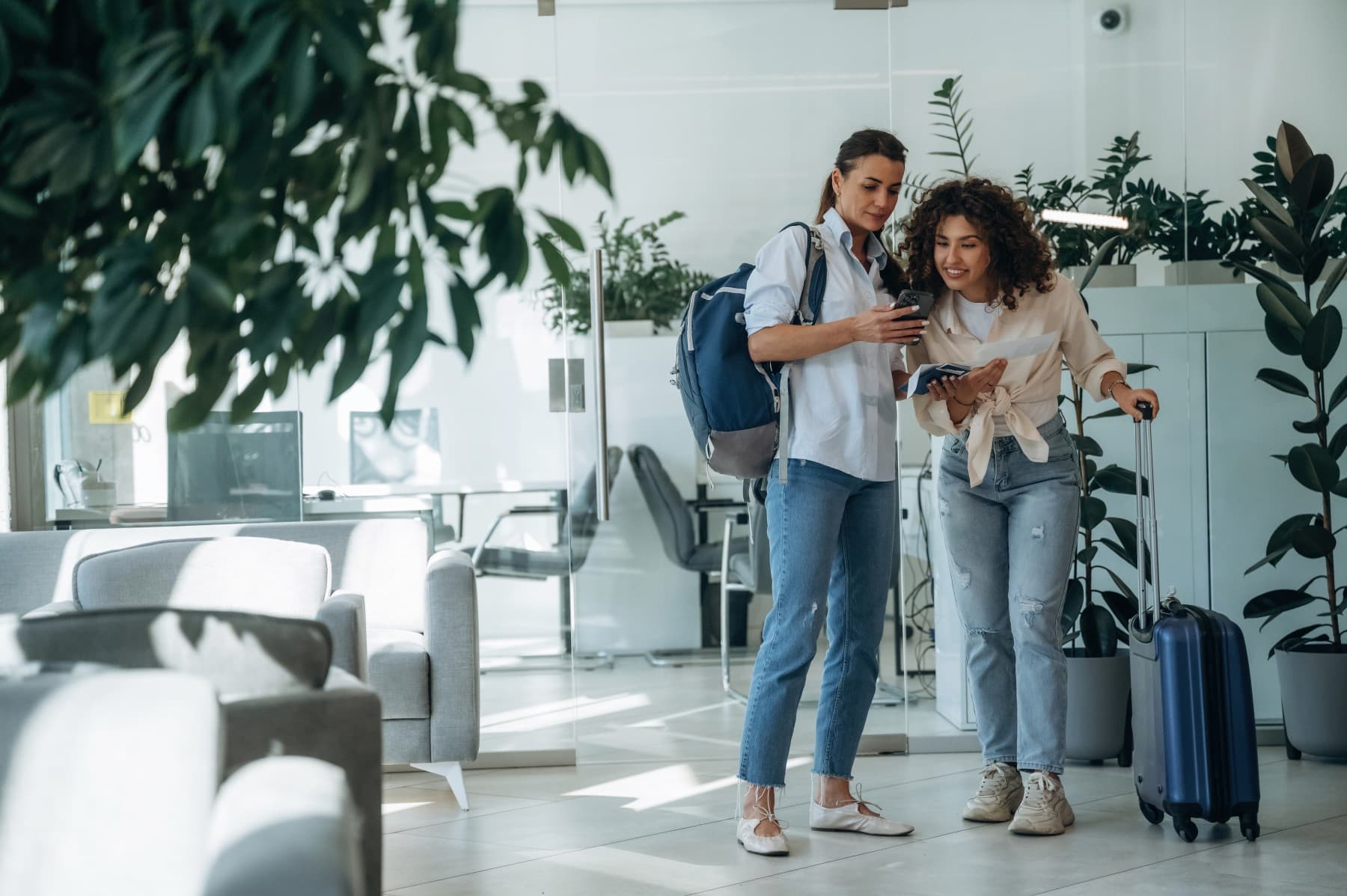 Two women travelers with luggage and tickets